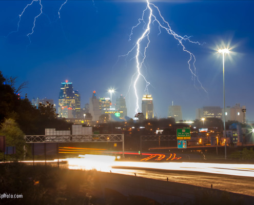 lightning above kansas city skyline with highway traffic motion